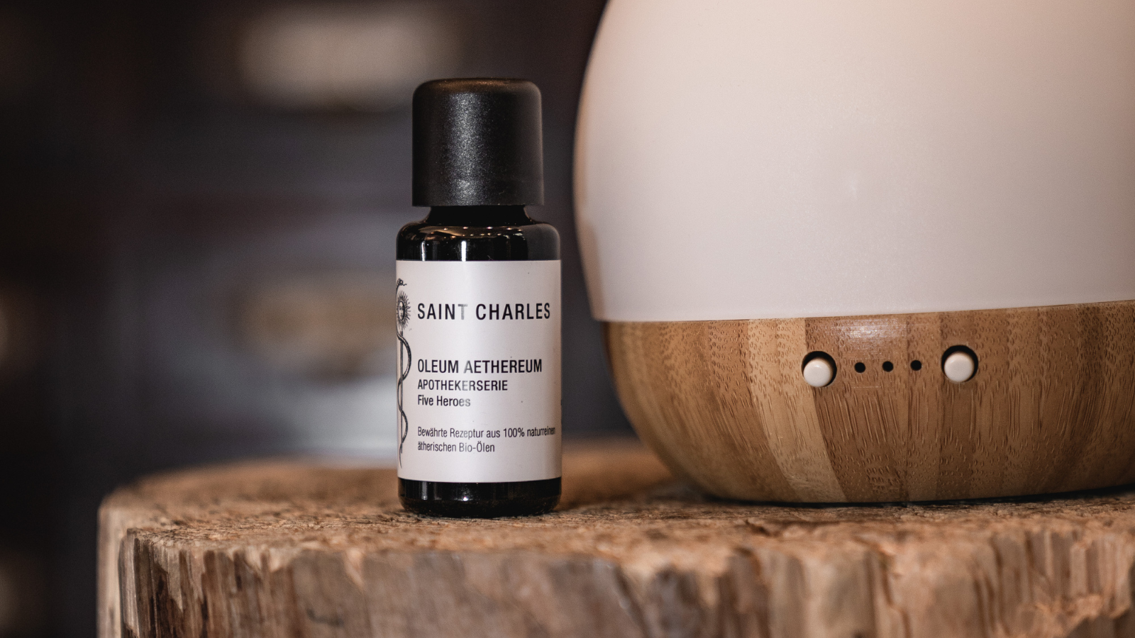 Saint Charles Aromaöl neben Diffuser auf Baumstamm