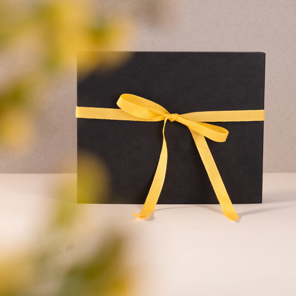 schwarze Geschenkbox mit gelben Band